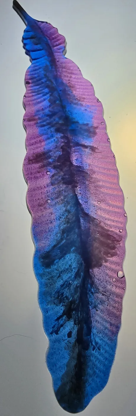 Handmade resin feather art piece in blue and violet tones